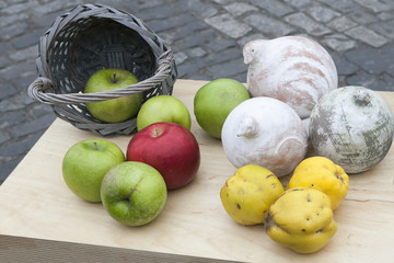 Autumn composition decorating the counter. Apples, quinces and lemons, together with eucalyptus and daisies on the table
