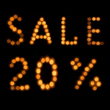 Blurred Inscription Sale 20% Of Burning Candles On A Black Background, Top View. Holiday Offer Discounts Of Five Percent Written In Bright Orange Lights.