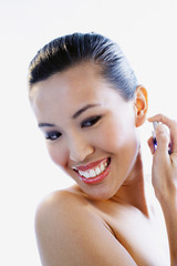 Woman spraying perfume, smiling