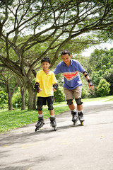 Obraz premium Father and son roller blading in park