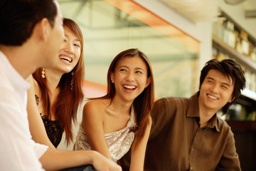 Young adults sitting together, smiling