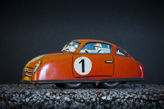 Vintage toy race car on dark background, number one printed on the side.