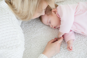 mother puts her baby daughter to sleep