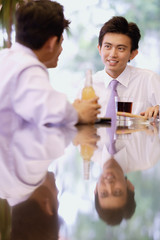 Young men sitting at bar counter with drinks