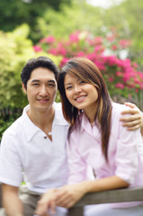 Couple looking at camera, man with arm around woman