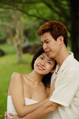 Fototapeta premium Couple embracing, woman looking at camera