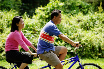 Couple cycling on tandem bicycle