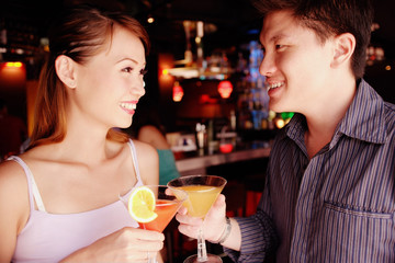 Couple standing and holding drinks