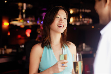 Couple standing face to face, holding drinks