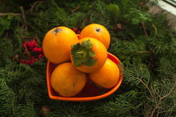 Fototapeta na wymiar Persimmon, asian sweet fruit, perfect source of vitamins in cold weather.