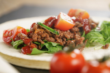 open tortilla with beef, frillice and vegetables