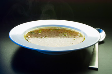 Ladle broth to the pan with the broth background top view 