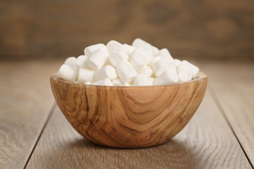 white marshmallows in wooden bowl on table