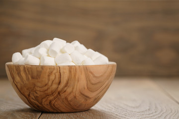 white marshmallows in wooden bowl on table