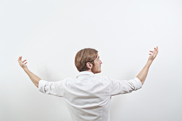 Young Adult Male in White Shirt Gesturing Arms Raised, Wide Open
