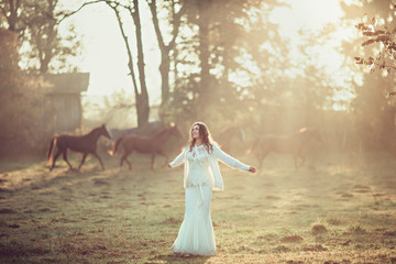 Amazing bride is posing alone with horses