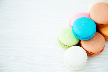 Assorted colorful french cookies macaroons on background. Space for text. Concept of the baking macaroons
