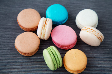 Assorted colorful french cookies macaroons on a black background