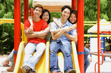 Fototapeta na wymiar Couples in playground, smiling at camera, portrait