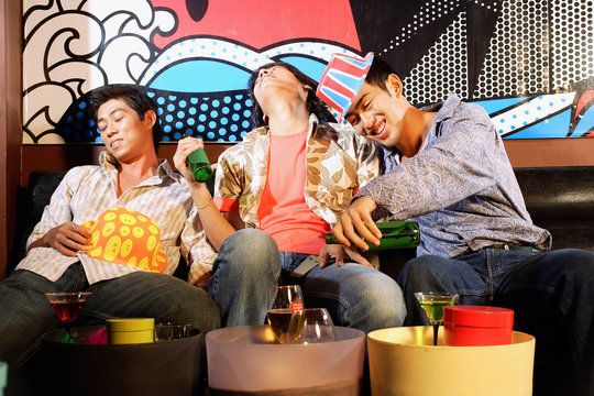 Three young men, at entertainment club, drinking