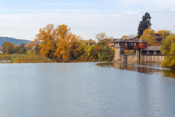 Fototapeta na wymiar Autumn river , colorful trees near the water in village.