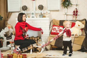 Happy mother and child boy playing together in a decorated Chris