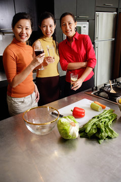 Women in kitchen, smiling at camera