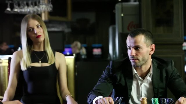 Two brutal men play at the Casino, surrounded by girls