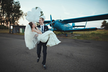 Lovely wedding couple near old blue plane