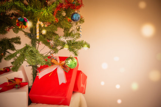 Decorated Christmas tree and gift on toned background