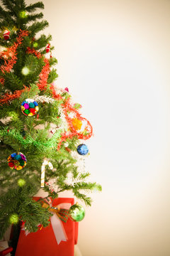 Decorated Christmas tree and gift on toned background