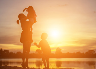 Mother encouraged her son outdoors at sunset, silhouette concept