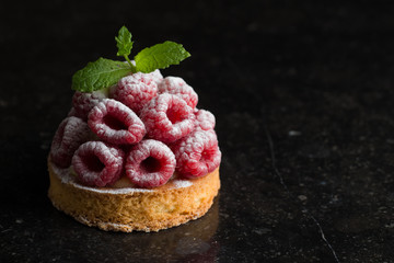 Raspberry tart dessert on dark background. Traditional french sweet pastry. Delicious, appetizing,...