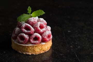  Raspberry tart dessert on dark background. Traditional french sweet pastry. Delicious, appetizing, homemade cake with custard, fresh berries and fruits. Copy space, closeup. Selective focus © sergiymolchenko