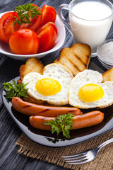 Breakfast on Valentine's Day - fried eggs in the shape of a heart and sausages. Top view