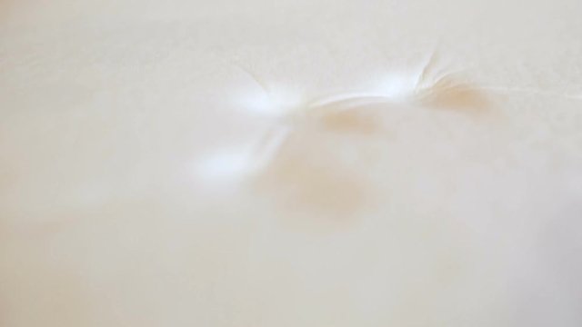 Hand of a man is Pressing on a Memory Foam White Pillow to test its Softness and Memory.