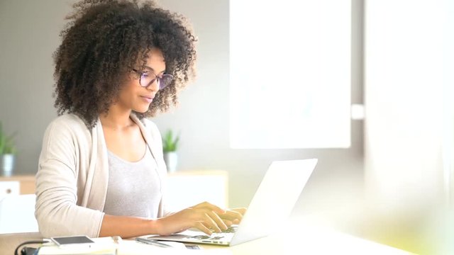 Mixed race woman working from home on laptop computer