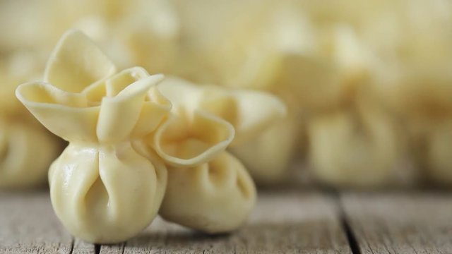 Closeup of saccottini pasta, traditional Italian handmade pasta filled with prosciutto. Slow motion.