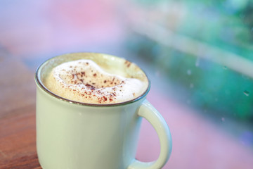 Cappuccino coffee milk foam with cinnamon powder in vintage coff