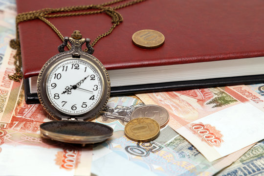 Time is money. Clock and diary on money background