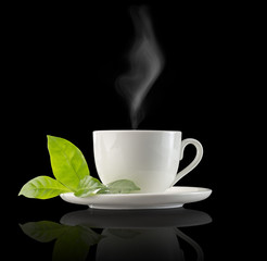 steamy coffee cup and leaves on black background