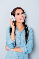 Cheerful happy woman listening favorite song in headphones