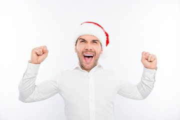 Excited happy man in santa's hat celebrating new year and triump