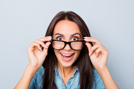 Wow! Pleasantly surprised cheerful woman touching glasses