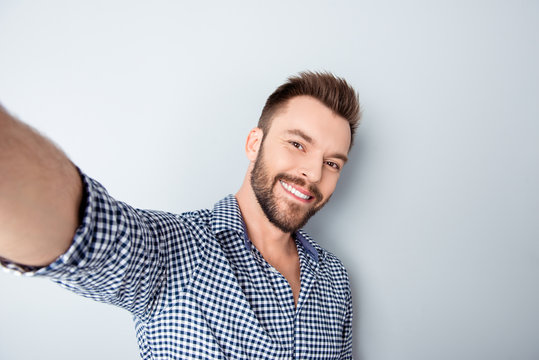 Happy smiling handsome bearded young man making selfie