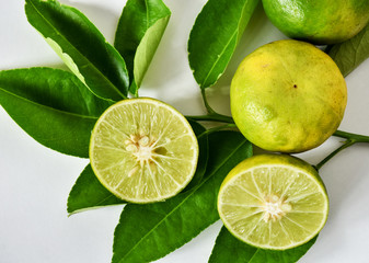 Fototapeta na wymiar Lemon fruits sliced on white background with leaves.Thailand local lemon round flat shape.