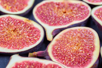 Pieces of fig on a stone board. Fruit background