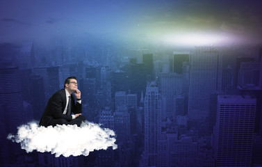 Fototapeta premium Man sitting on a cloud above the city