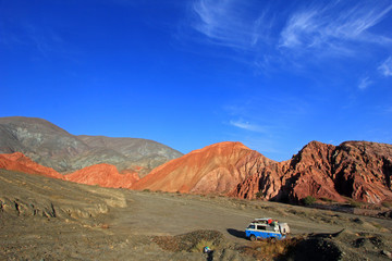 Van on the hill of seven colors, cerro de los siete colores, at Purmamarca, UNESCO world heritage quebrada de humahuaca, Jujuy, Argentina
