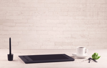 Office desk closeup with white brick wall
